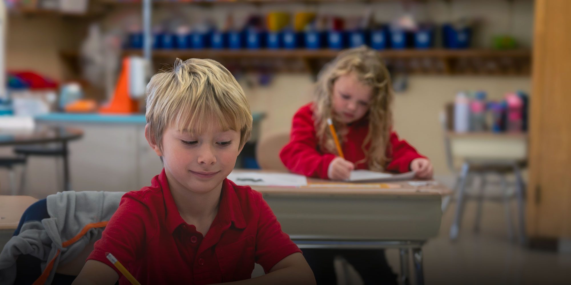 Students writing with pencils at their desks.